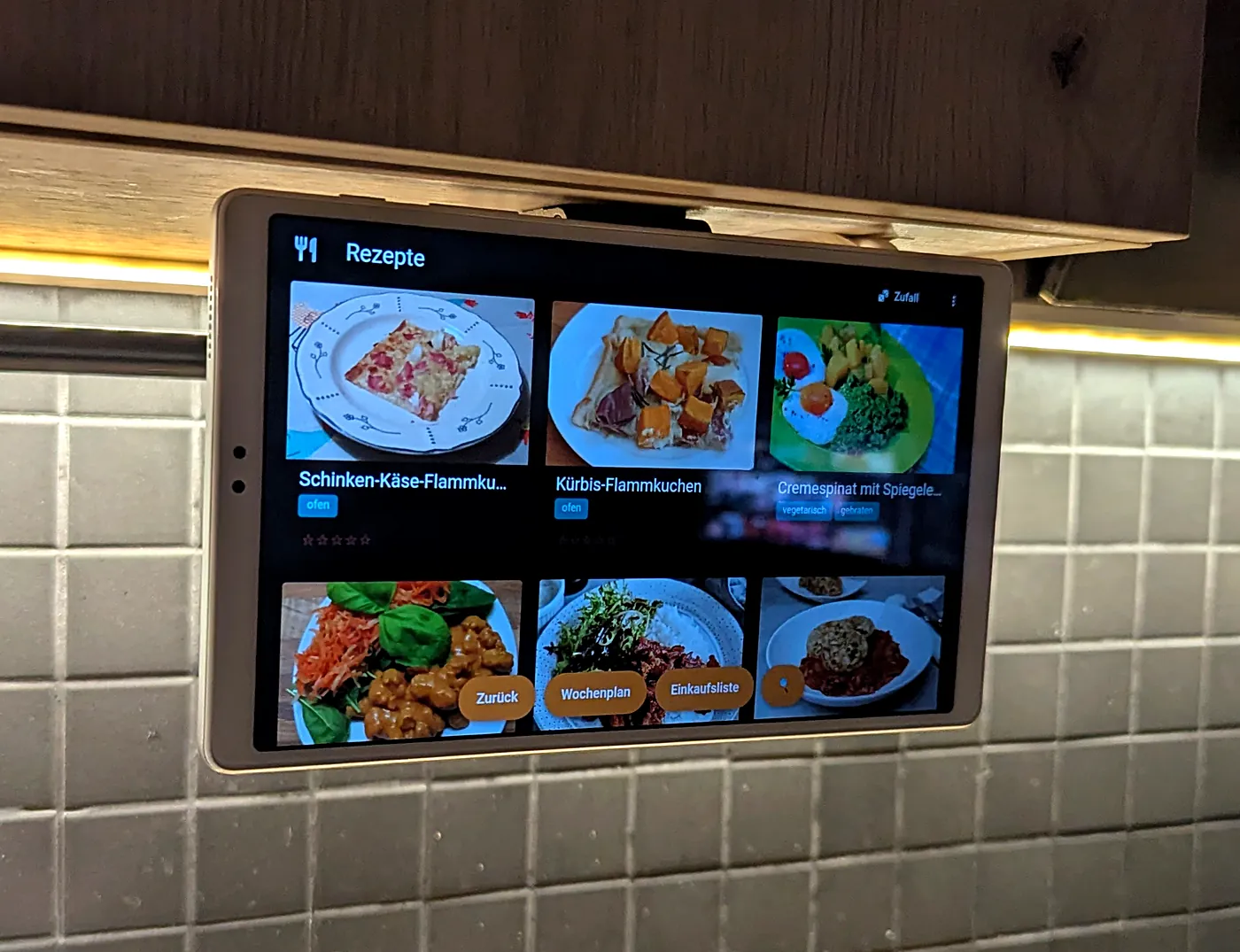Tablet flipped down under the wall cabinet, landscape, showing a recipe list