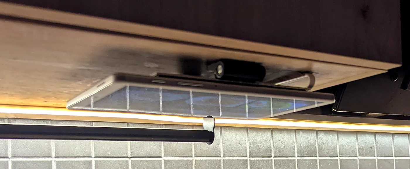 Tablet flipped up, lying flat under the cabinet floor, display facing down